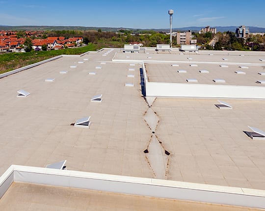 view of the industrial flat roof with roof windows and ventilation system